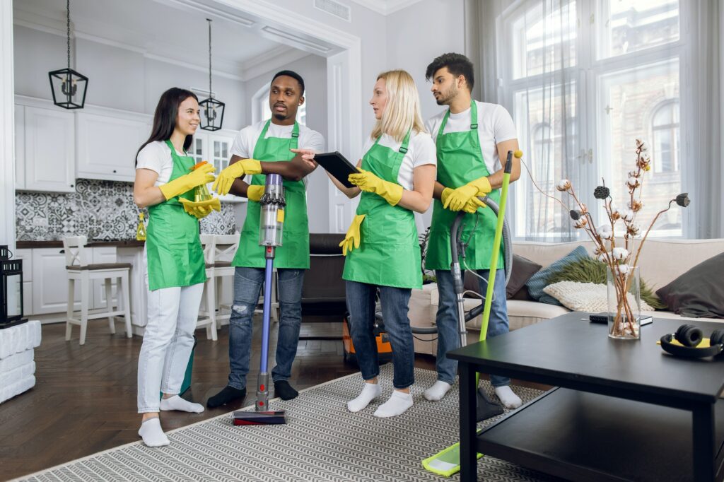 Multiracial team of cleaning service using digital tablet